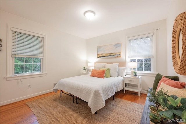 bedroom featuring wood finished floors and baseboards