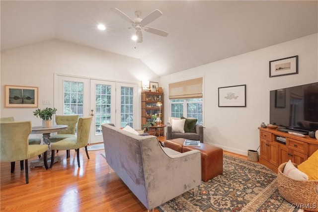 living room with ceiling fan, lofted ceiling, and light wood-style floors