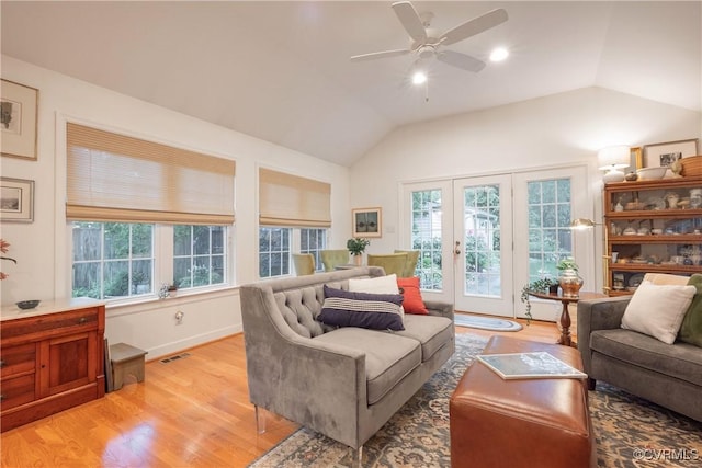 living room featuring plenty of natural light, vaulted ceiling, light wood finished floors, and a ceiling fan