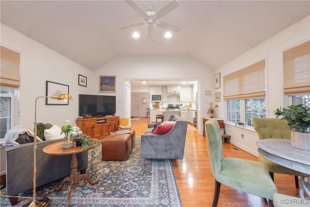 living area with a ceiling fan, light wood finished floors, and lofted ceiling