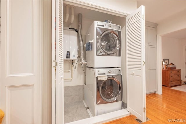 washroom featuring stacked washer and clothes dryer and light wood-style floors