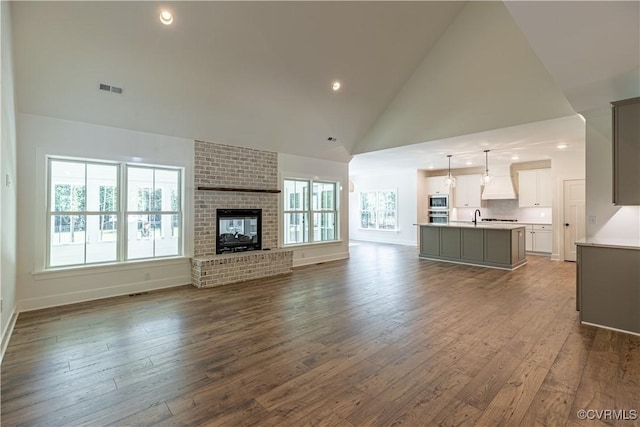 15148 Johns Trace Cir, Montpelier, VA 23192 - unfurnished living room with high vaulted ceiling, dark wood finished floors, a sink, baseboards, and recessed lighting