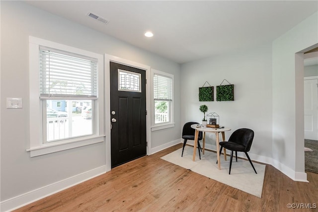 foyer entrance featuring baseboards, wood finished floors, and recessed lighting
