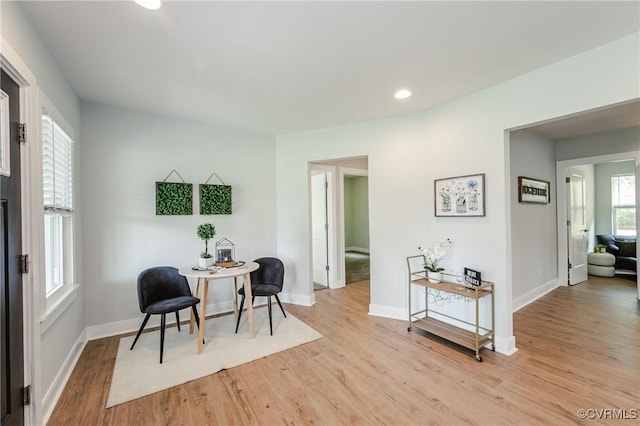 living area featuring light wood-style flooring, baseboards, and recessed lighting
