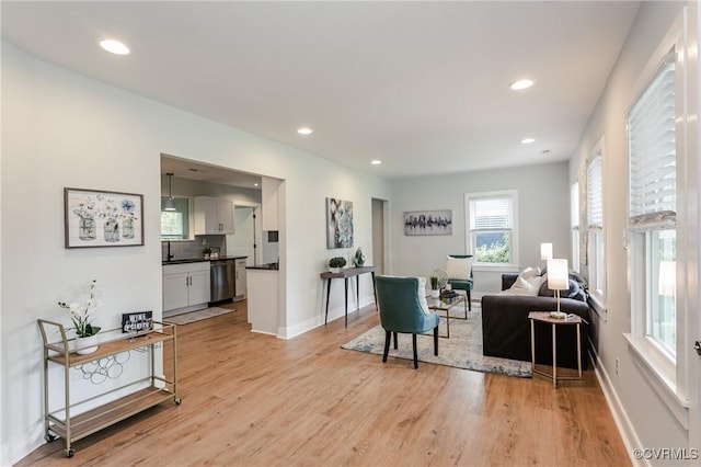 living area featuring light wood-style floors, recessed lighting, and baseboards