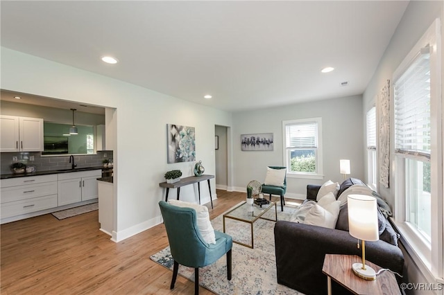 living room with light wood-type flooring, baseboards, and recessed lighting