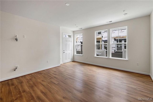 unfurnished living room with wood finished floors and baseboards