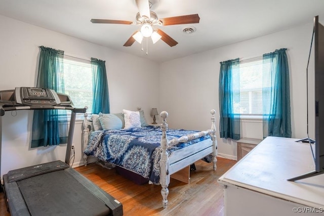 bedroom with wood finished floors, ceiling fan, and baseboards