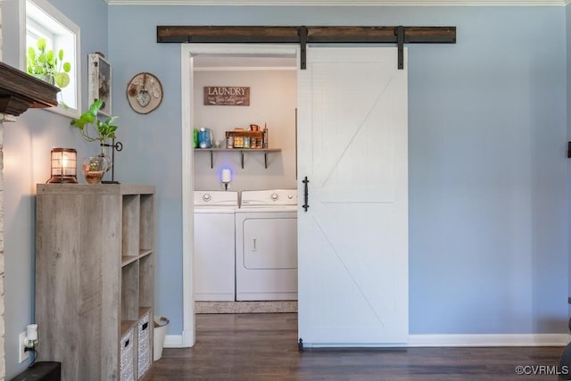 laundry area featuring washing machine and clothes dryer, dark wood-style floors, baseboards, and a barn door
