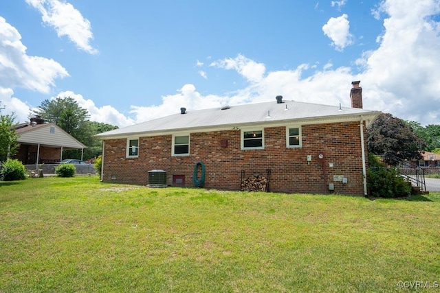 back of house with a chimney, brick siding, and cooling unit