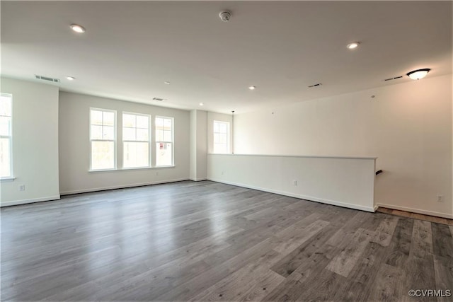 spare room featuring dark wood-type flooring, recessed lighting, baseboards, and a smoke detector