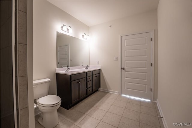bathroom with tile patterned flooring, toilet, double vanity, and baseboards