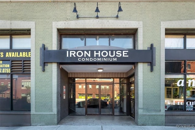 view of exterior entry featuring brick siding