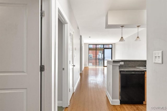 hallway featuring light wood-style flooring and baseboards