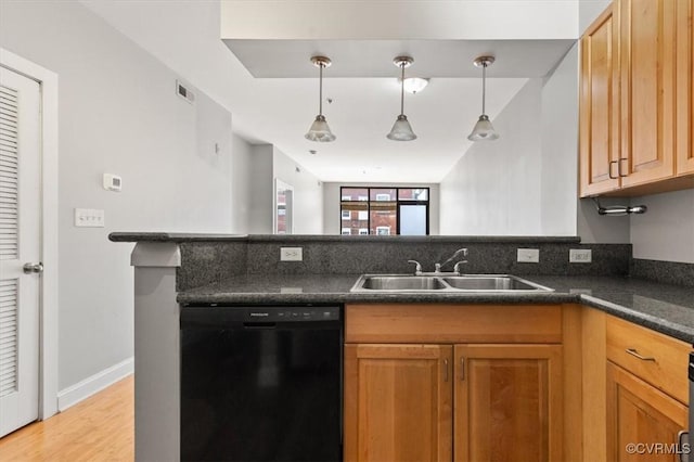 kitchen featuring dishwasher, a sink, dark countertops, light wood finished floors, and a peninsula