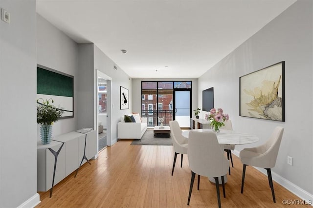 dining space with light wood finished floors and baseboards