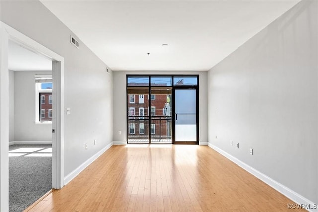 unfurnished room featuring baseboards and light wood finished floors