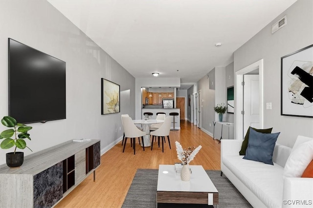 living room with light wood-type flooring and baseboards