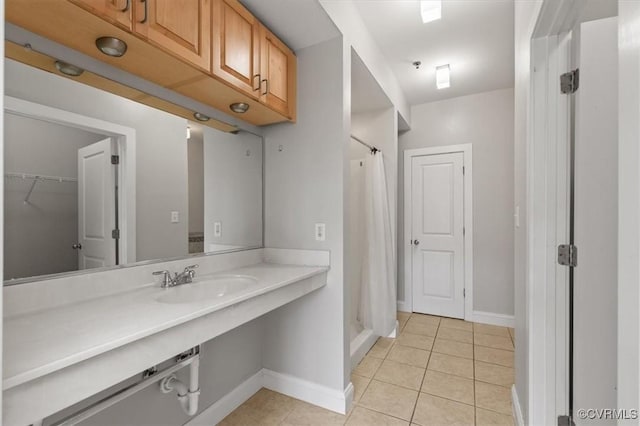 full bath with tile patterned floors, a sink, baseboards, and a shower with shower curtain