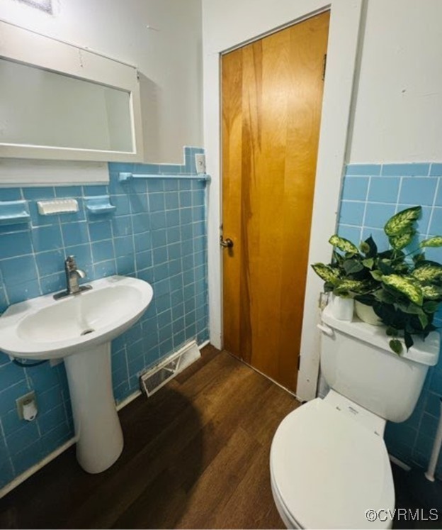 705 Endly St, Chase City, VA 23924 - half bath featuring tile walls, wood finished floors, a wainscoted wall, and toilet