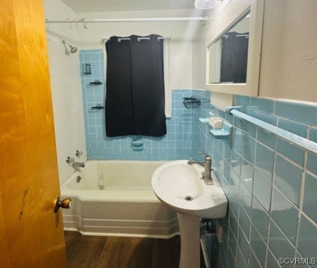 705 Endly St, Chase City, VA 23924 - bathroom featuring shower / tub combination, tile walls, wood finished floors, a sink, and a wainscoted wall