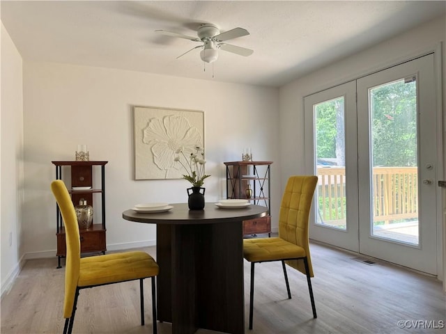 dining room with light wood finished floors, ceiling fan, and baseboards