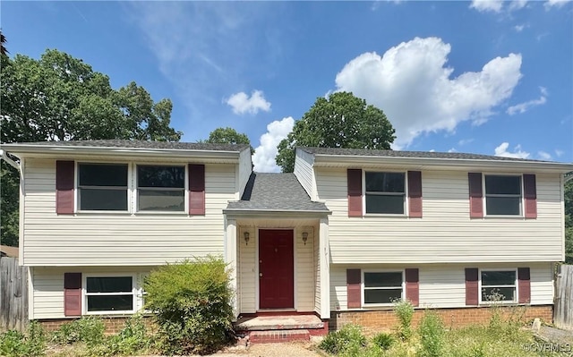 view of front of home with brick siding and fence