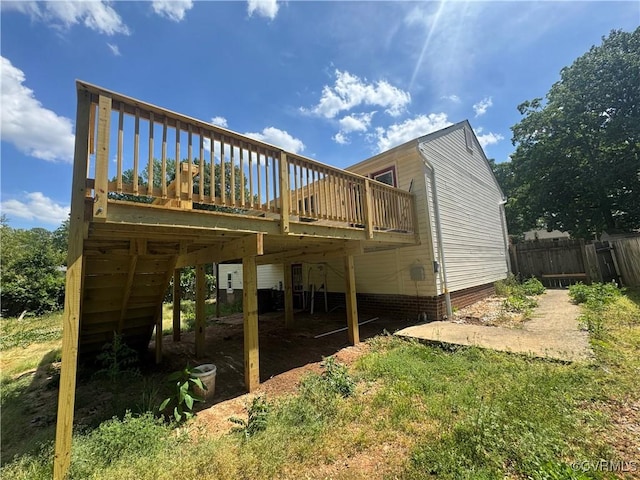 rear view of house with a deck and fence