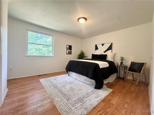 bedroom with light wood finished floors and baseboards