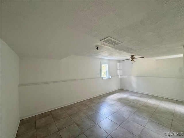bonus room featuring a ceiling fan, a textured ceiling, tile patterned floors, and baseboards