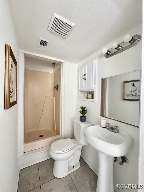 full bath featuring a stall shower, baseboards, toilet, and tile patterned floors