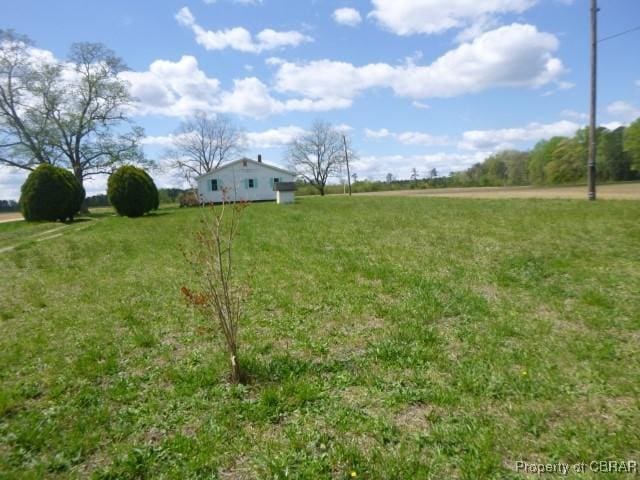 view of green lawn featuring a view of rural / pastoral area