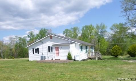 view of front of house featuring a front lawn, a deck, and central AC