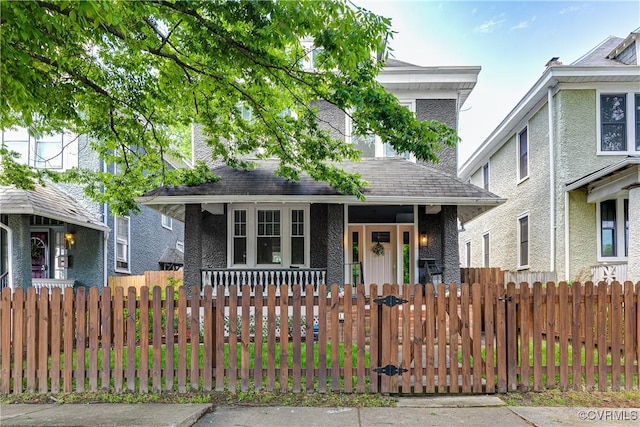 view of front facade with a porch and a fenced front yard