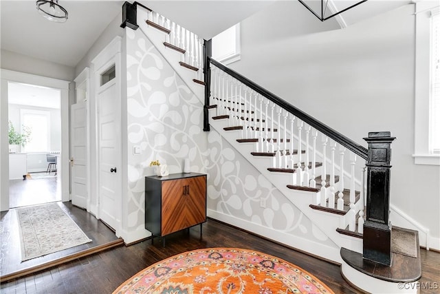 staircase featuring wood finished floors and baseboards