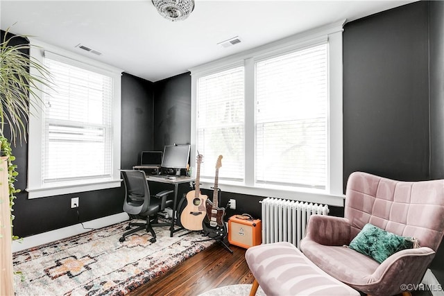 office space with radiator, wood finished floors, and plenty of natural light