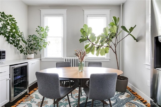 dining area with beverage cooler, radiator heating unit, and plenty of natural light