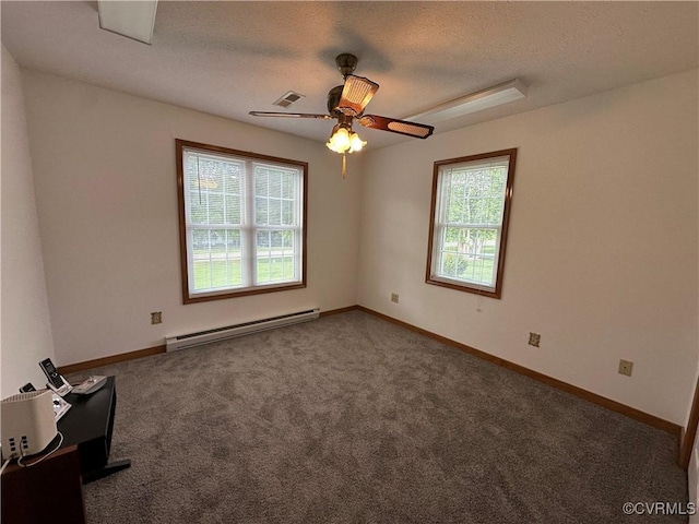 spare room featuring a baseboard heating unit, plenty of natural light, carpet, a ceiling fan, and a textured ceiling