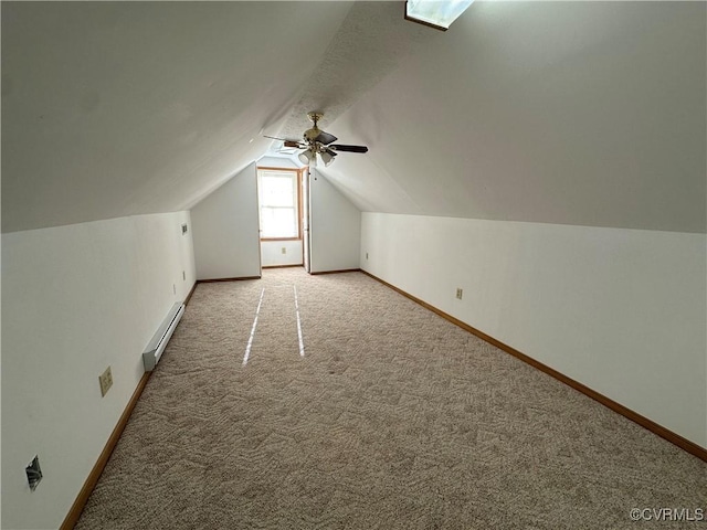 additional living space with baseboard heating, light carpet, baseboards, a ceiling fan, and lofted ceiling