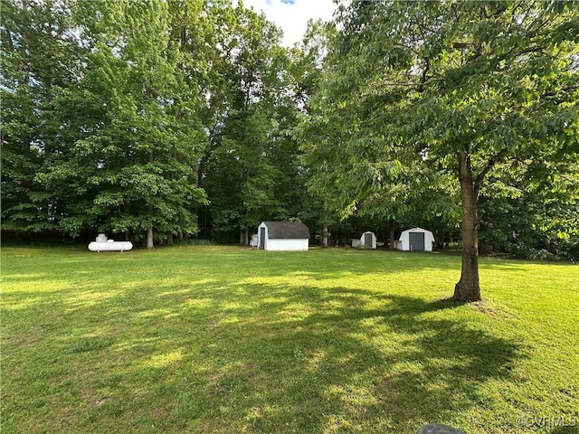 view of green lawn featuring a storage unit and an outdoor structure