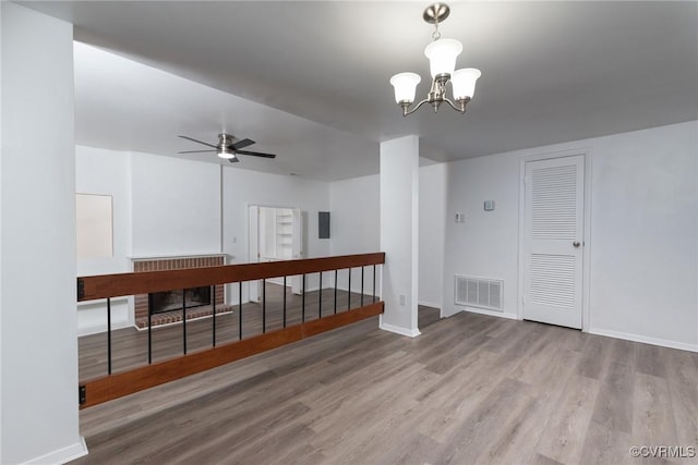 spare room with wood finished floors, baseboards, a chandelier, and ceiling fan