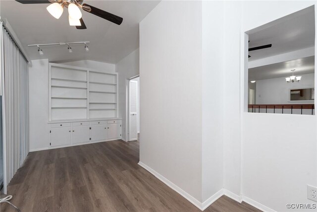 corridor with wood finished floors, baseboards, track lighting, and a chandelier