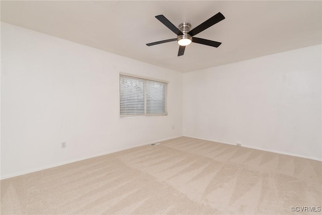 spare room with carpet floors, a ceiling fan, and baseboards