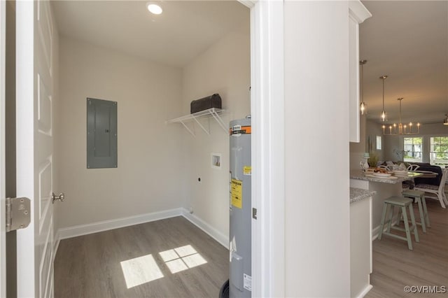 clothes washing area with electric panel, washer hookup, water heater, hookup for an electric dryer, and wood finished floors