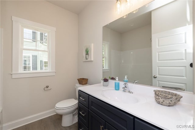 bathroom with wood finished floors, toilet, baseboards, and vanity