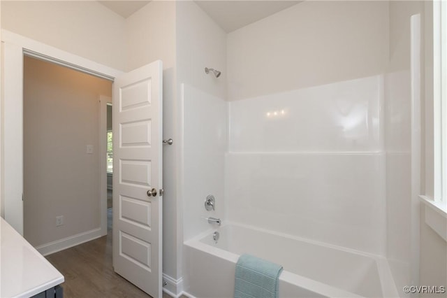 full bathroom featuring shower / tub combination, wood finished floors, baseboards, and vanity