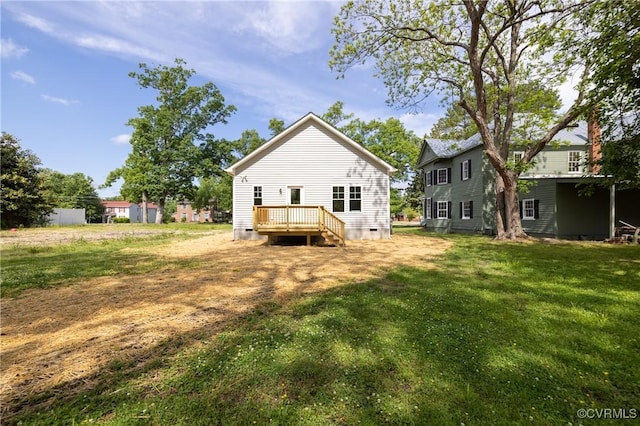 rear view of property featuring crawl space, a wooden deck, and a lawn