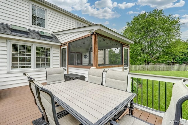 wooden deck featuring a sunroom and outdoor dining space
