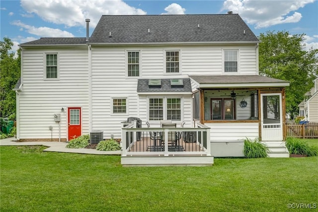 rear view of property featuring a sunroom, a yard, central AC, and a deck