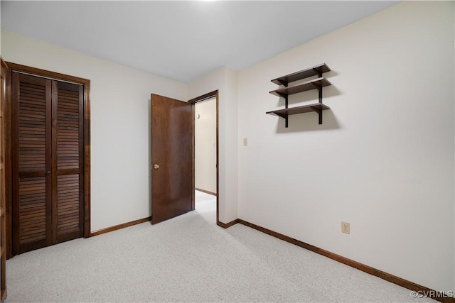 unfurnished bedroom with baseboards, carpet floors, and a closet
